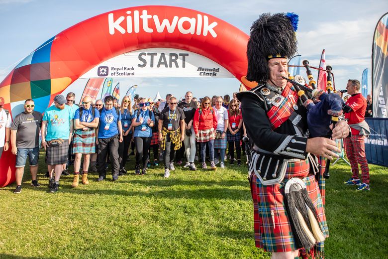 Bagpiper plays in front of start line at Kiltwalk